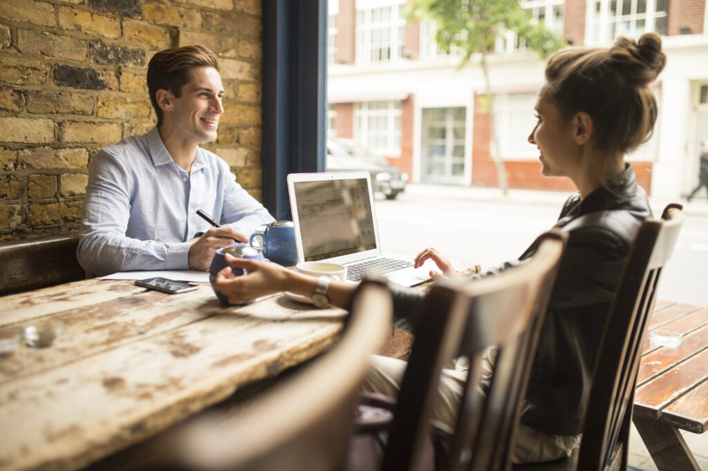 Businessman and woman working in cafe, London, UK