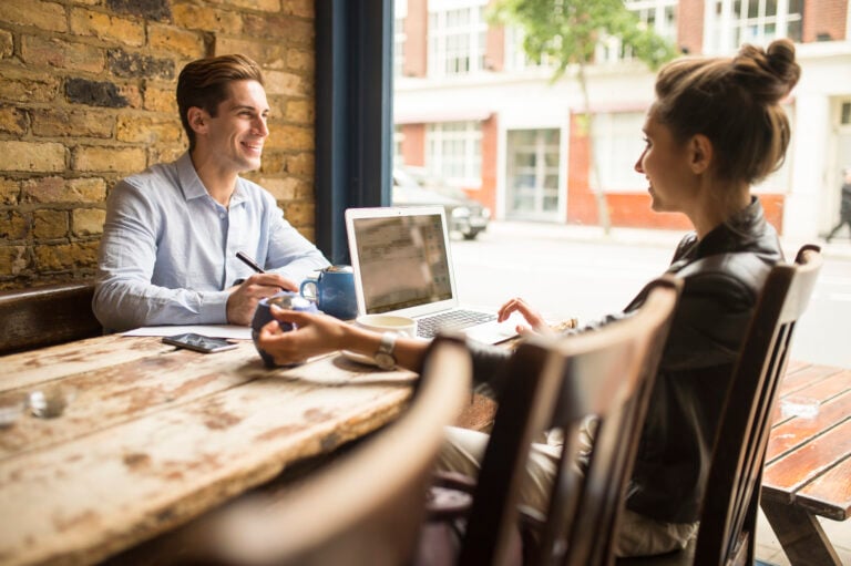 Businessman and woman working in cafe, London, UK